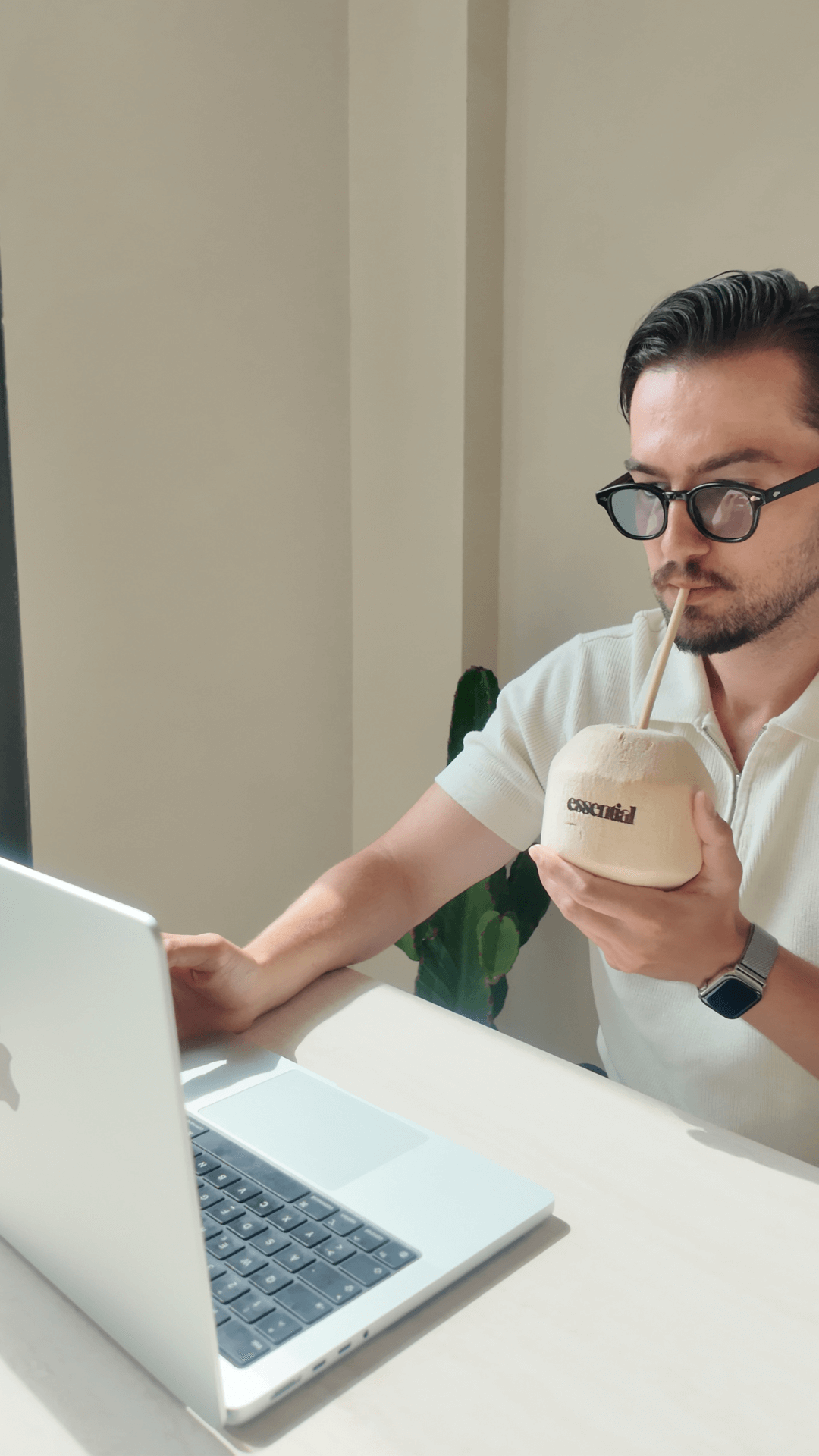 Startup-Founder Amir trinkt einen frischen Kokosdrink und arbeitet im Essential Café Frankfurt Ostend – tropischer Vibe in der City