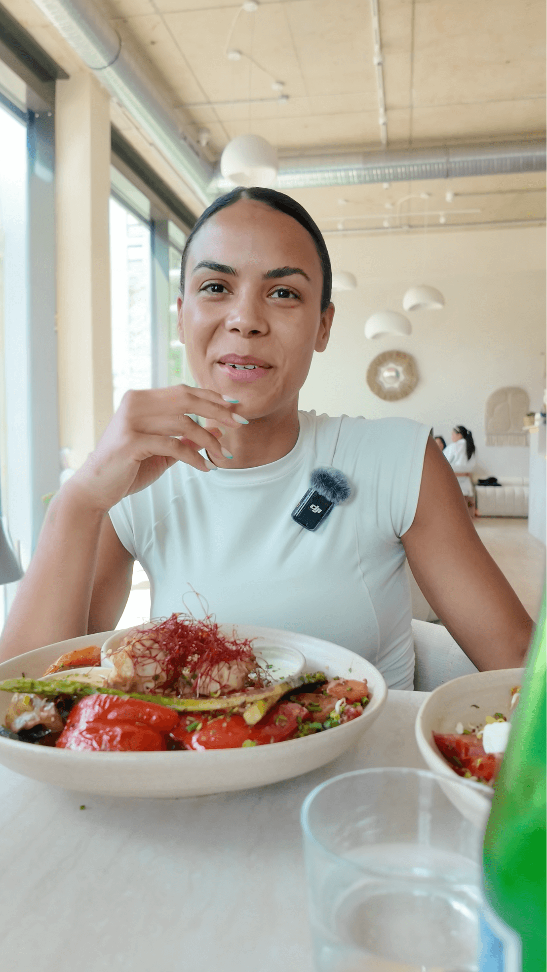 Steph, HIIT-Enthusiastin, genießt eine pflanzliche Falafel Bowl im Essential Café Frankfurt Ostend – Energie nach dem Workout.